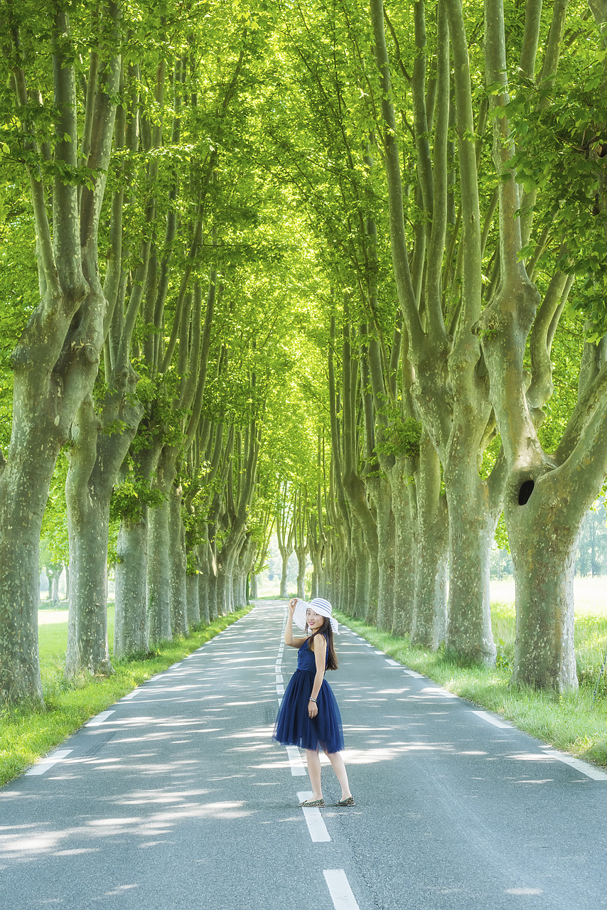 #150334-1 - Chinese Woman Standing in Tree-lined Road, Provence, France