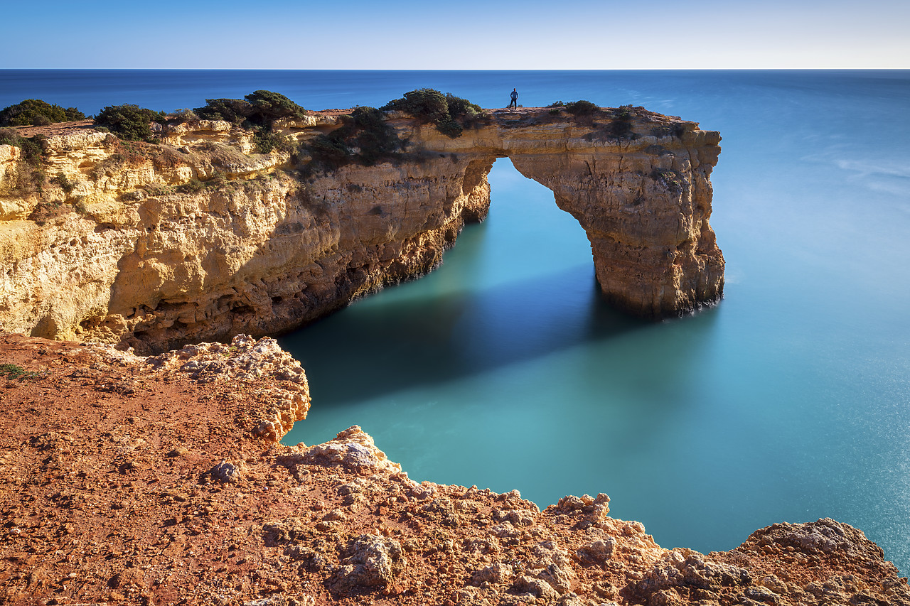 #400011-1 - Person on Natural Sea Arch, Praia da Albandeira, Algarve, Portugal